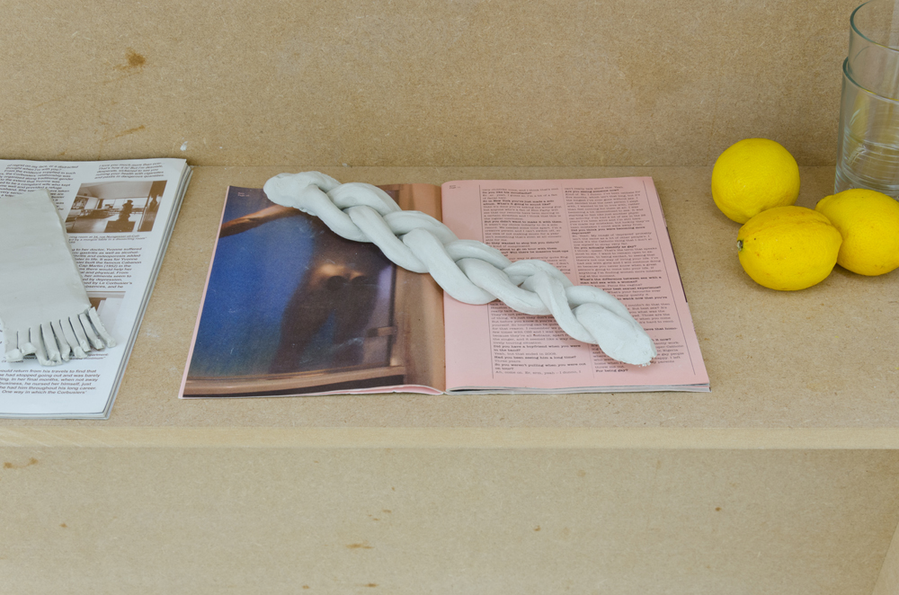 Close up image of plaited clay on a magazine with lemons and glasses