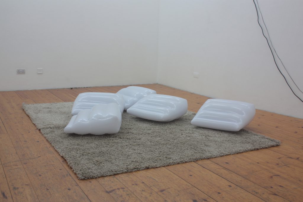 White inflatable sex wedge cushions on a cream rug