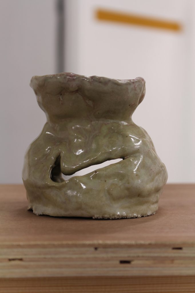 A grey ceramic oil burner with a Nike swoosh pattern.