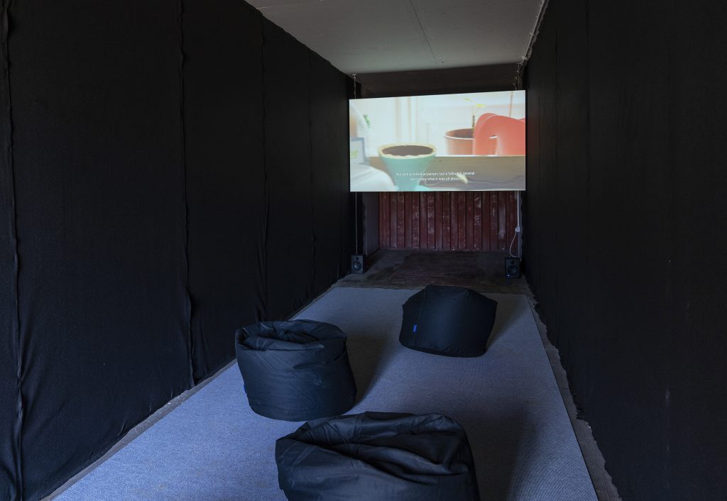 Projection of the video Vaseline with beanbags in the foreground 