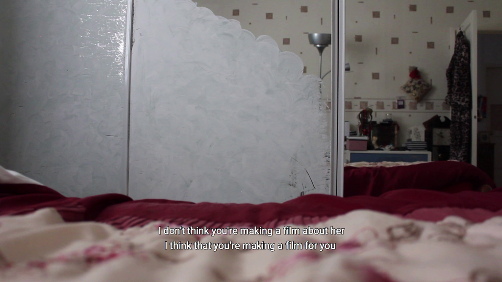 Mirrored wardrobe partially painted white in a bedroom with the caption 'I don't think you're making a film about her I think that you're making a film for you'