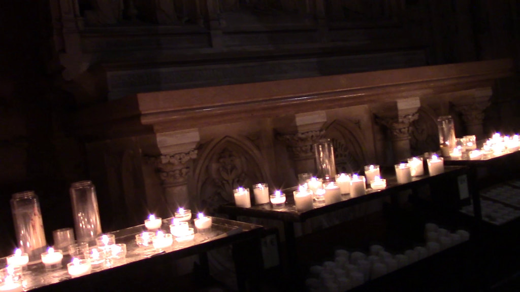 three tables of prayer candles in a church