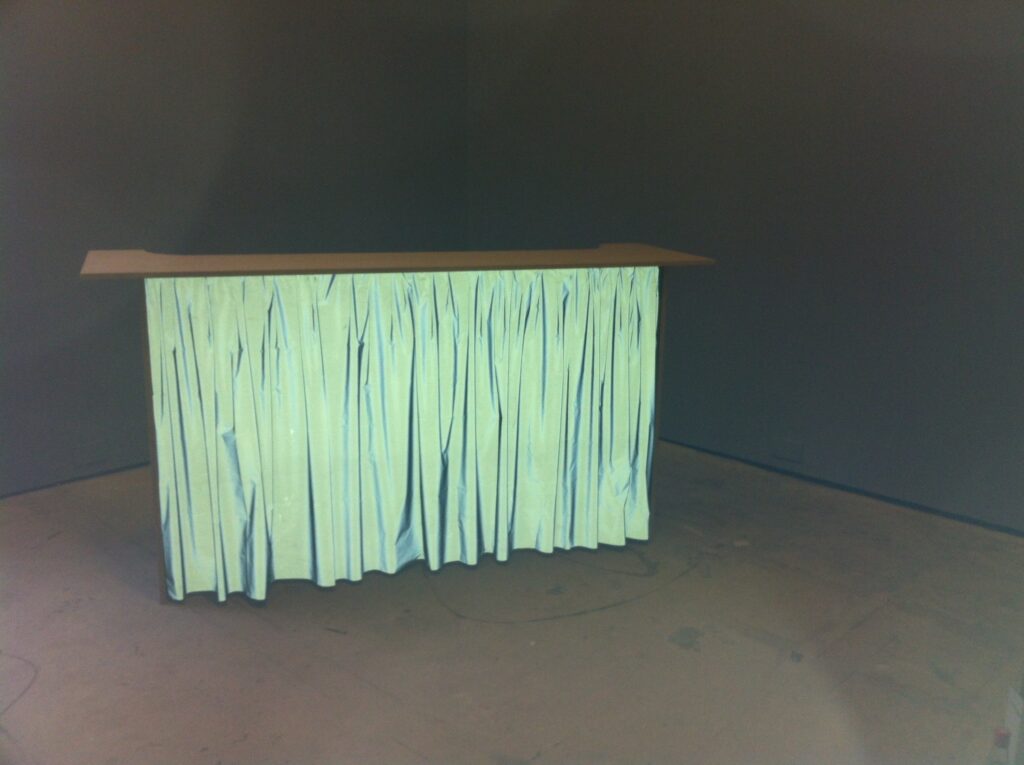 flash photograph of wooden bar in the corner of a room with a gathered retroreflective fabric front