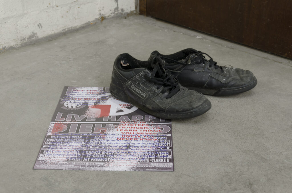 a pair of dirty beat up black reebok trainers on a rave style poster