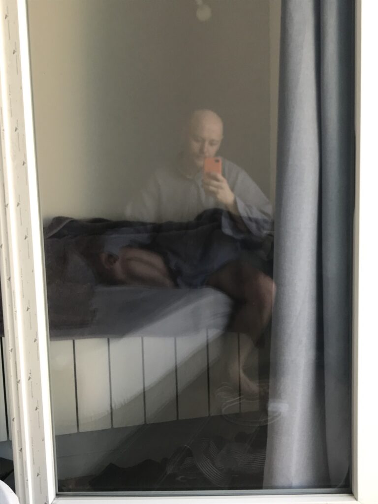 photo of reflection of me in glass window in a blue and white pyjama shirt